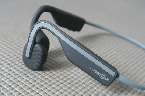 Słuchawki AfterShokz, idealne, gdy zastanawiasz się, jakie słuchawki na rower wybrać. Pozwalają słyszeć otoczenie.
