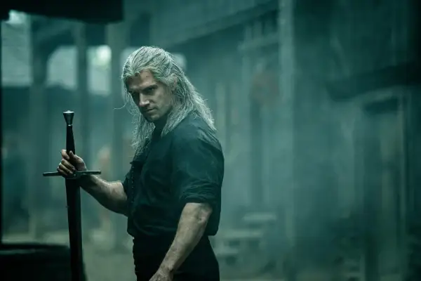 Geralt z Rivii, **the witcher**, z długimi, siwymi włosami i mieczem w dłoni, spogląda groźnie.