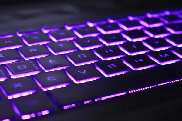 Klawiatura laptopa Lenovo z fioletowym podświetleniem. Dowiedz się, jak włączyć podświetlenie klawiatury w laptopie Lenovo, aby ułatwić sobie pracę w ciemności.